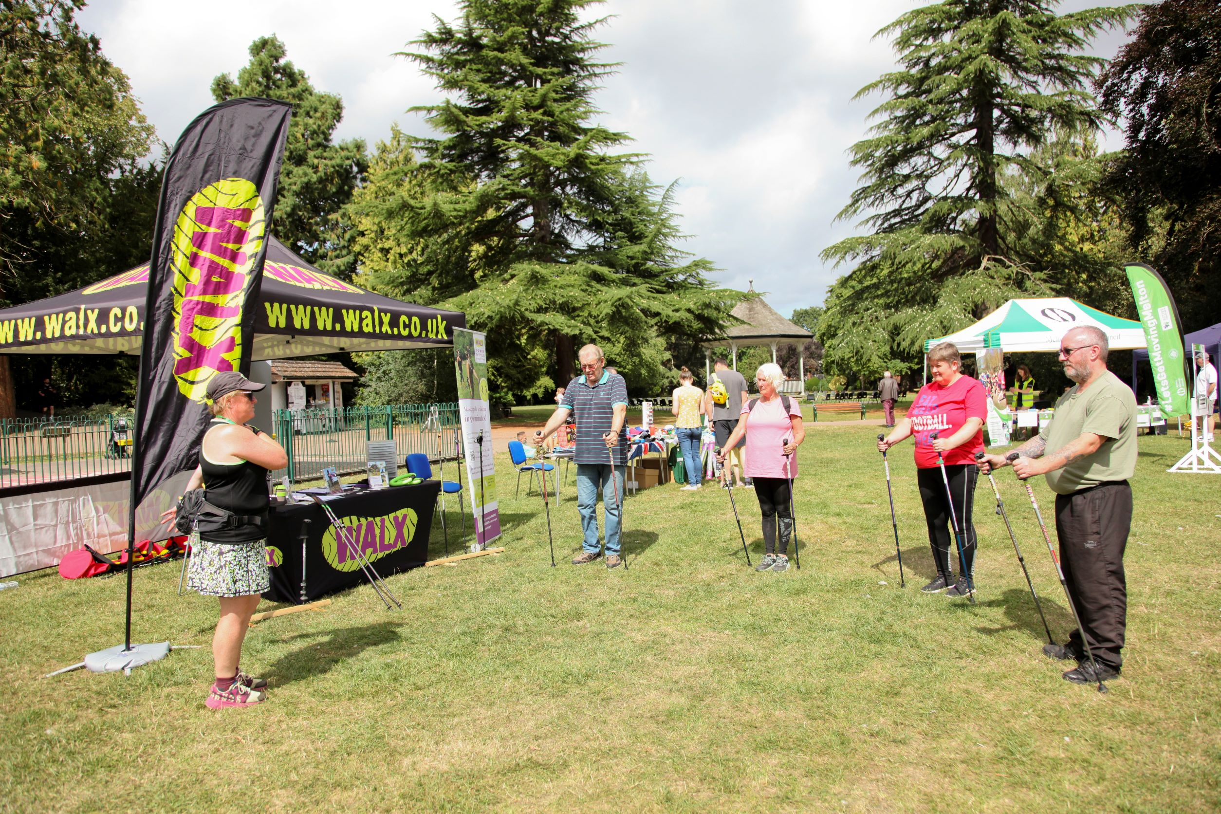 A group of adults standing in front of a branded gazebo