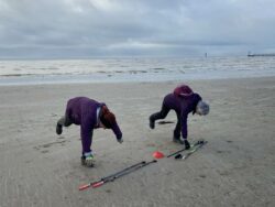 Ladies exercising with poles on beach